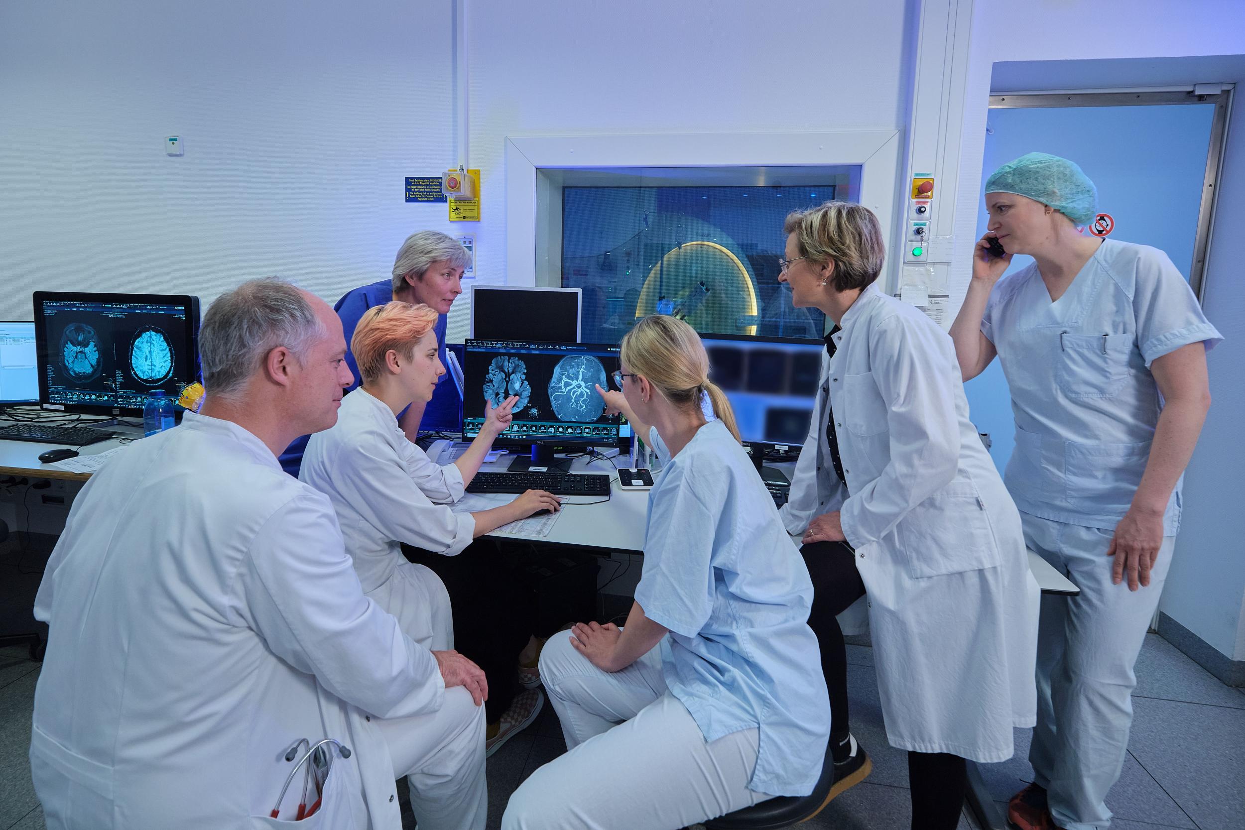 Ein medizinisches Team wertet MRT-Bilder des Gehirns an einem Computer aus