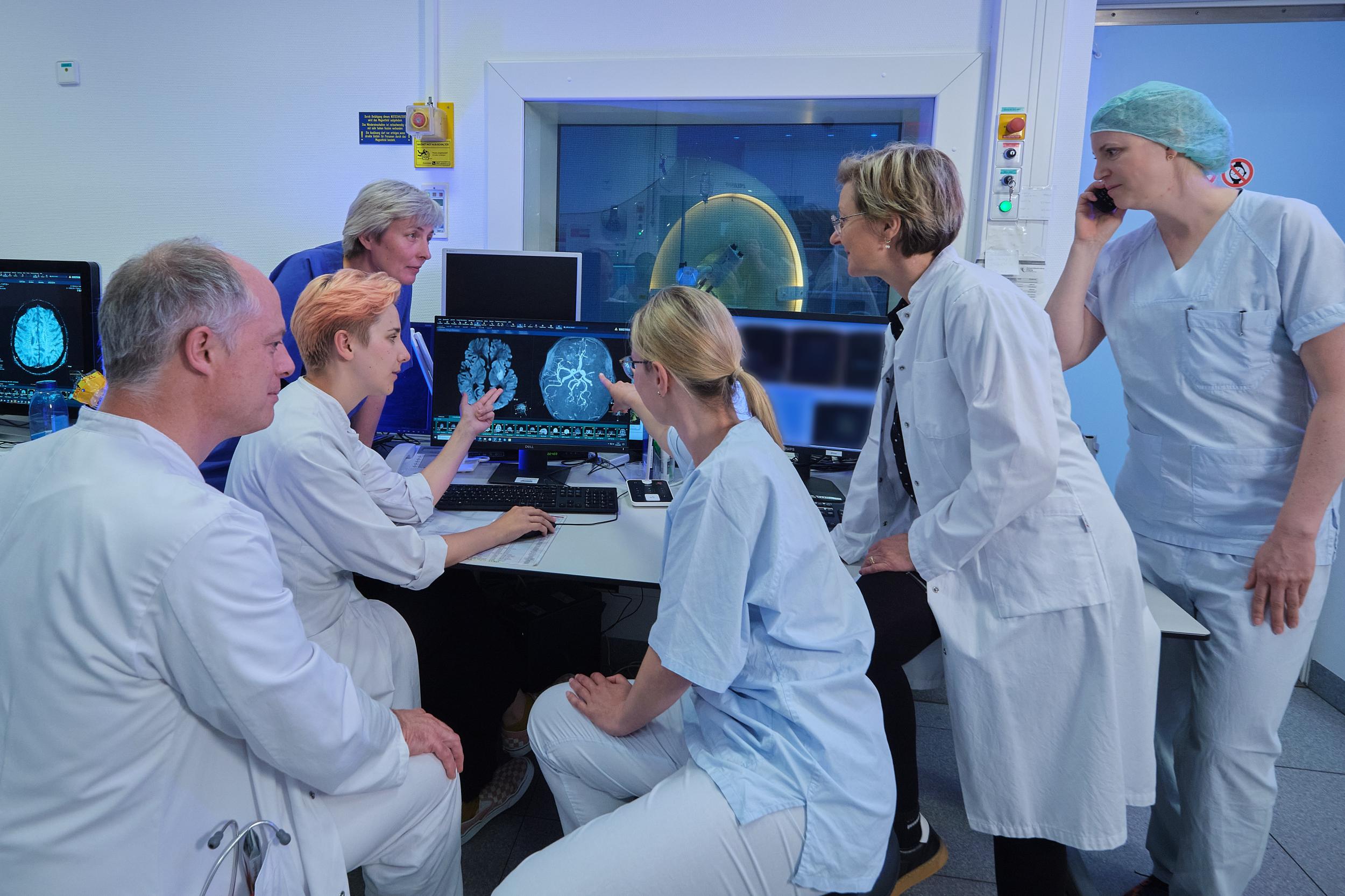 Medizinisches Team bei der Auswertung von Bildern eines Gehirns am Computer. 