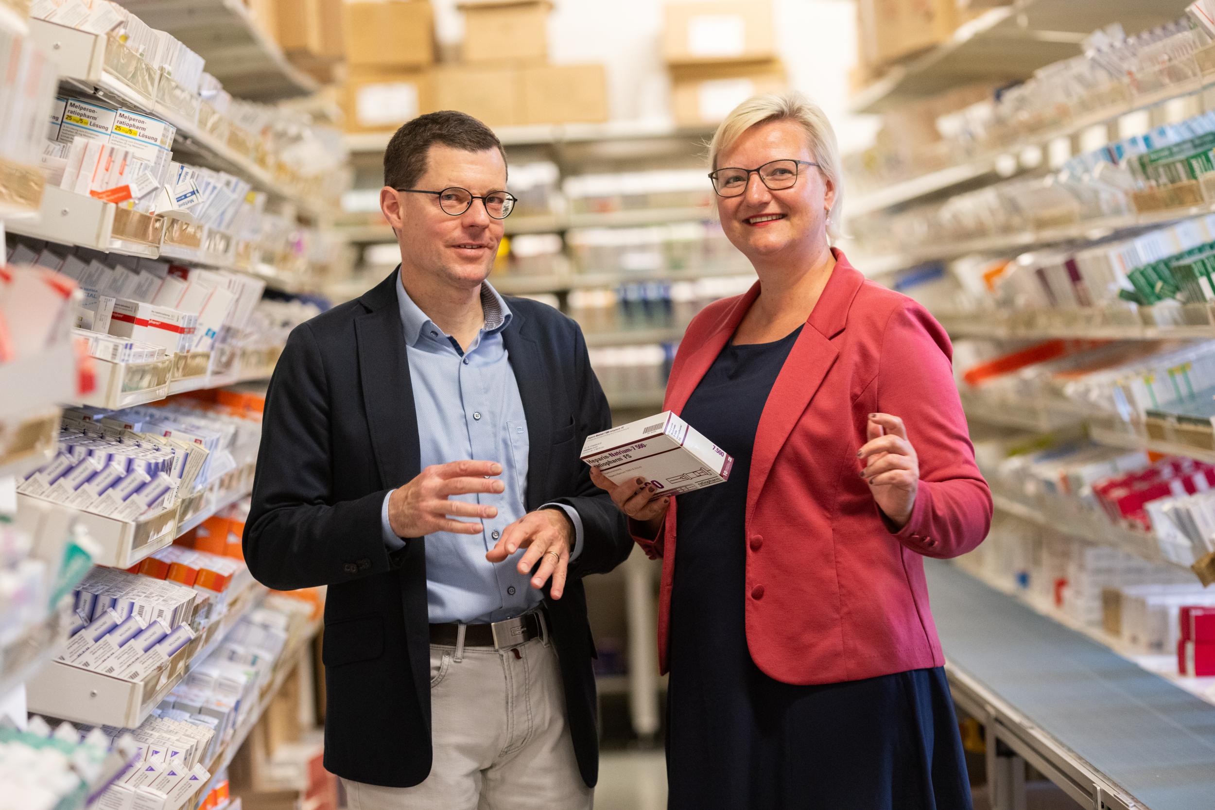 Prof. Thilo Bertsche, Fachapotheker für Klinische Pharmazie, und Dr. Yvonne Remane, Leiterin der UKL-Apotheke umgeben von aufgereihten Medikamenten. 