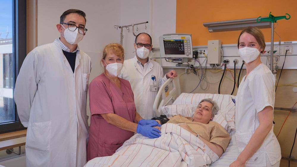 Ein medizinisches Team am Bett einer Patientin. 