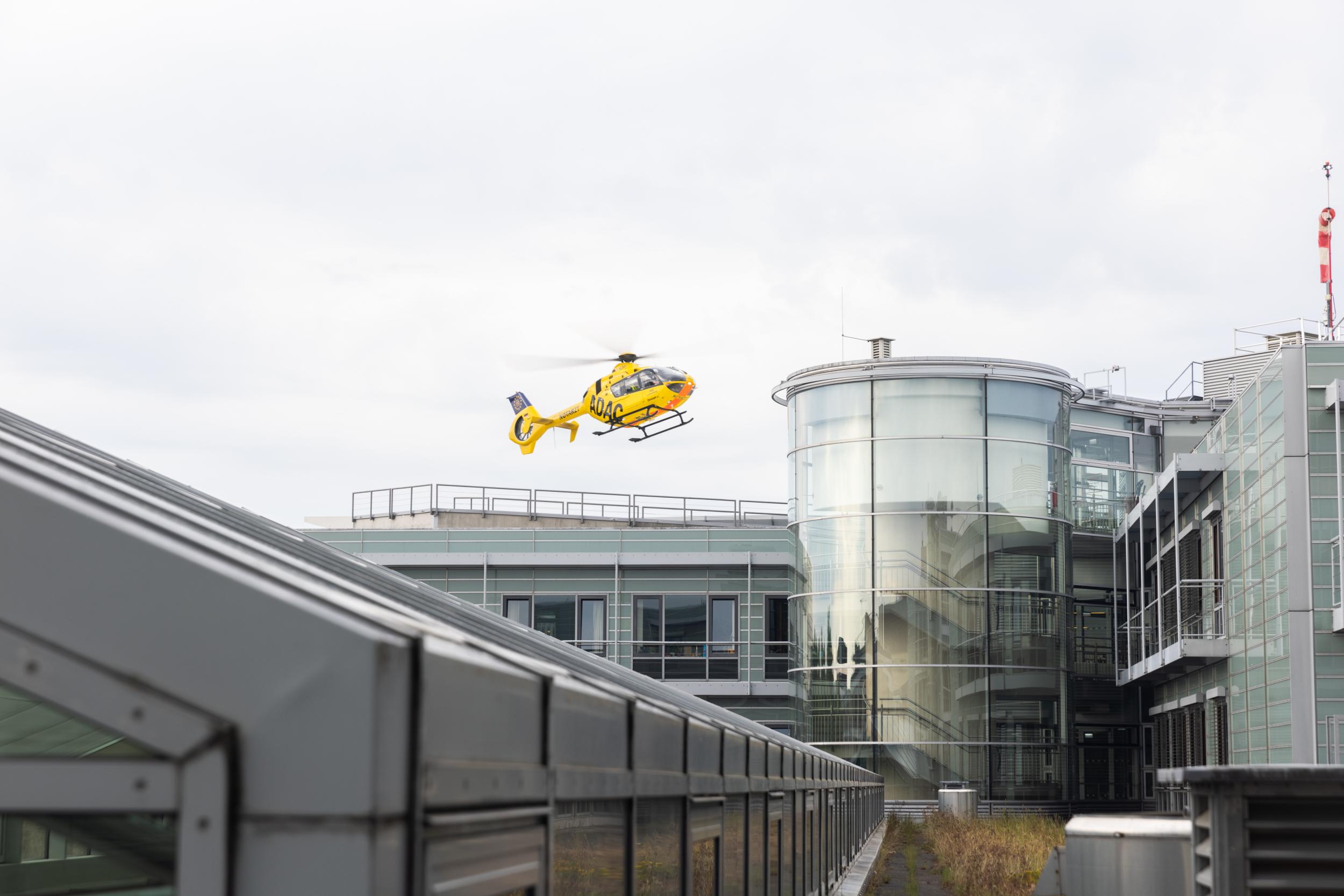 Hubschrauber im Flug wenige Meter über dem Landeplatz des UKL.